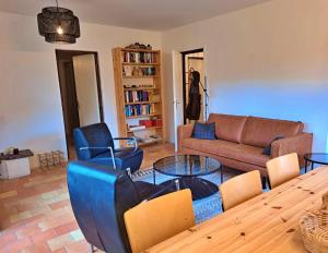 a living room with a couch and a table and chairs at Vakantie Woning Le Chat Maison 175 in Écuras