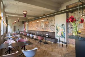 a dining room with tables and chairs and a brick wall at Hotel Sonne in Zittau