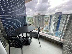 a balcony with a table and chairs and a large window at Salinas Exclusive Resort in Salinópolis