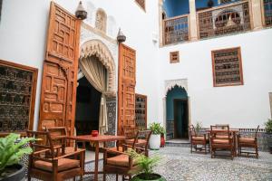 einen Innenhof eines Gebäudes mit einem Tisch und Stühlen in der Unterkunft Dar Shaeir in Rabat