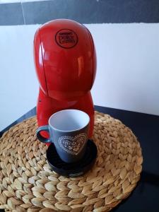 una cafetera sentada en una mesa con una taza de café en El Callejón del Molino, en Lucena