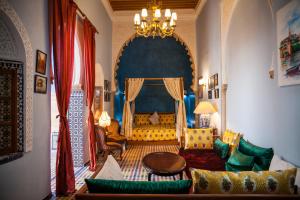 Una sala de estar con un sofá y una lámpara de araña. en Dar Shaeir, en Rabat