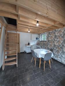 a kitchen and dining room with a table and chairs at La Tanière du Lac in Robertville