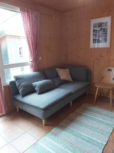 a blue couch in a living room with a window at Chalet Chocolat in Hohentauern