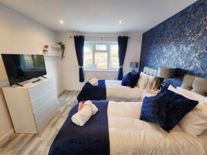 1 Schlafzimmer mit 2 Betten, einem Sofa und einem TV in der Unterkunft Home From Home Wembley in Preston