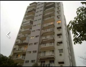 un edificio de apartamentos alto con un reloj. en Apartamento no Joia da Barra, en Río de Janeiro