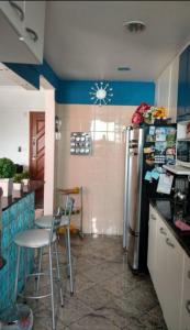 cocina con nevera, mesa y sillas en Apartamento no Joia da Barra, en Río de Janeiro
