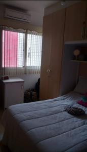 1 dormitorio con 1 cama grande y 2 ventanas en Apartamento no Joia da Barra, en Río de Janeiro