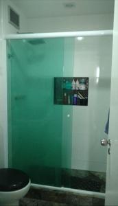y baño con ducha de cristal y aseo. en Apartamento no Joia da Barra, en Río de Janeiro