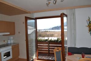 kuchnia z dużymi szklanymi drzwiami prowadzącymi na balkon w obiekcie Gästehaus Lindermuth w mieście Presseggersee