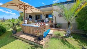 a backyard with a hot tub and an umbrella at Clanwilliam Oasis - Naturism, Boating, Hiking & more in Clanwilliam