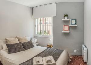 a bedroom with a large bed with towels on it at Apartamento New Folch Sevilla A in Seville