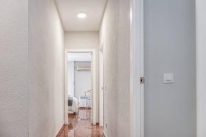 um corredor com paredes brancas e um corredor branco com em Apartamento New Folch Sevilla A em Sevilha