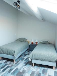 two beds sitting in a room with a ceiling at Maison Salamandre in Remoulins