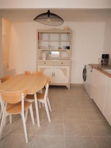 a kitchen with a wooden table and chairs in a room at Maison Salamandre in Remoulins