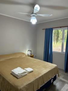een slaapkamer met een bed met twee handdoeken erop bij Cabañas del Arroyo Villa Ventana in Villa Ventana