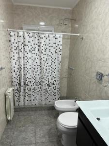 a bathroom with a shower and a toilet and a sink at Cabañas del Arroyo Villa Ventana in Villa Ventana