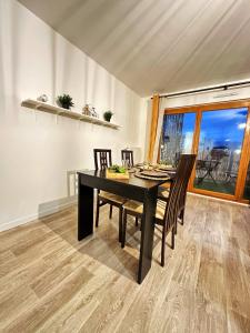 uma sala de jantar com uma mesa preta e cadeiras em La plaine paisible - 15’ Paris 10’ Stade de France em Saint-Denis