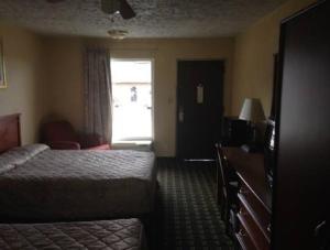 a hotel room with a bed and a window at Regal Inn Guntersville in Guntersville