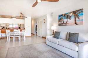 a living room with a couch and a table and a kitchen at Hau'Oli at Waikoloa Hills #902 in Waikoloa Village