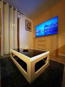 a living room with a tv and a coffee table at La plaine paisible - 15’ Paris 10’ Stade de France in Saint-Denis