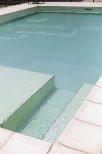a swimming pool with water in the middle at El Fulgor - Posada - Chacras de Coria in Mayor Drumond