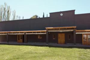 a large black building with a grass field at El Fulgor - Posada - Chacras de Coria in Mayor Drumond