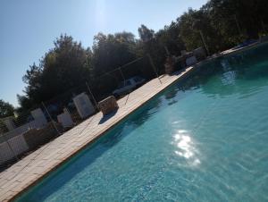 una gran piscina de agua con valla y sillas en Casa no Campo en Algoz