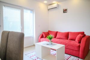 a living room with a red couch and a table at Sara 4 in Soko Banja