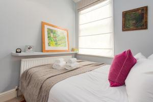 מיטה או מיטות בחדר ב-Charming flat in leafy West London by UnderTheDoormat