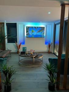 a living room with a table and blue lights at ESCAPE ZEN Oasis tropicale & Spa privatif in Loon-Plage
