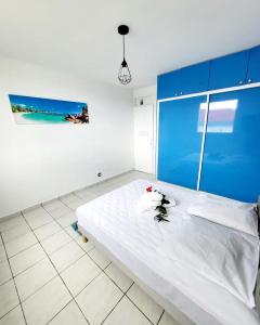 una camera con un letto bianco e una parete blu di Villa aka merlot a Le Moule