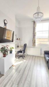 a living room with a chair and a television at Bright 1-bedroom Apartment by River Thames in Surbiton