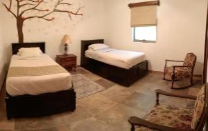 um quarto com duas camas e uma árvore em Quinta San José de las Palomas em Parras de la Fuente