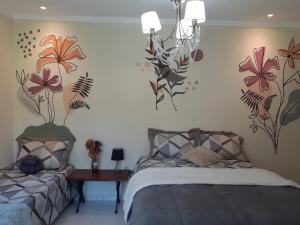 1 dormitorio con 2 camas y flores en la pared en Excelente casa - família ou grupo - 35 Km C Jord, en Santo Antônio do Pinhal