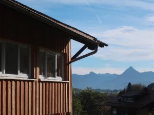 une maison avec des fenêtres et des montagnes en arrière-plan dans l'établissement Vogelmann Suite, à Pfronten