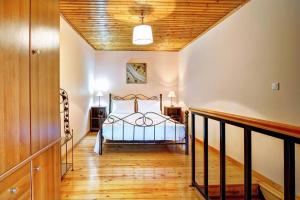 a bedroom with a bed and a wooden ceiling at Vavilato Home Kouramades in Kouramádes