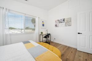 a white bedroom with a bed and a window at Steps Away From Pismo Beach with Poker, Foosball, FREE EV Charger, and Bikes in Oceano