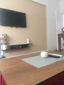 sala de estar con mesa y TV en la pared en Bello Depto Vintage Zona Céntrica en La Plata