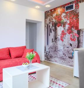 a living room with a red couch and a wall mural at Sara 4 in Soko Banja