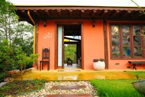 uma casa laranja com uma porta da frente e um pátio em Recanto EmmAnnEssência em Gravatal