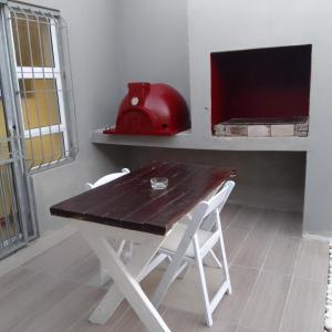 una mesa de madera con 2 sillas blancas y un casco rojo en Naliya Guest house en Ciudad del Cabo