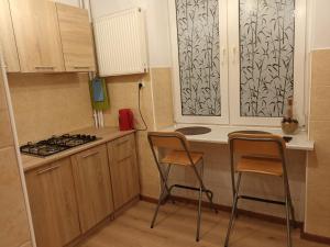 une petite cuisine avec deux chaises et une cuisinière dans l'établissement Apartament Eliot, à Varsovie