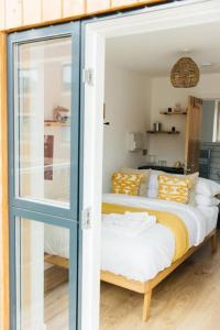 a bedroom with a bed with a glass door at Carmen Eco-Pod / Treehouse, Close to Cabot Circus in Bristol