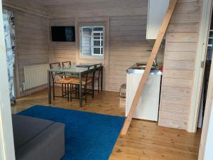 a small room with a table and a kitchen at Kappelshamns Veranda och Fritidsboende in Kappelshamn