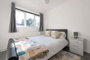 1 dormitorio con cama y ventana en Lovely 1 bedroom maisonette close to Airport, Town and Train Station en Luton