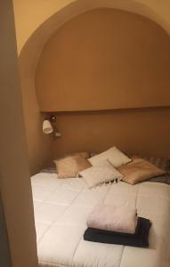 Una cama grande con almohadas encima. en Giulia Appartamento, 250mt da Ponte Vecchio, en Florencia 10 fotos más