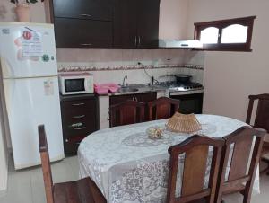 une cuisine avec une table et un réfrigérateur blanc dans l'établissement ALOJAMIENTO TEMPORARIO, à Paso de los Libres
