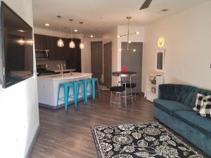 a living room with a blue couch and a kitchen at High rise Near UNLV and Strip in Las Vegas