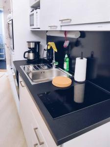 a kitchen with a sink and a counter top with aounter sidx sidx sidx at New Studio Wave near Airport in Vantaa